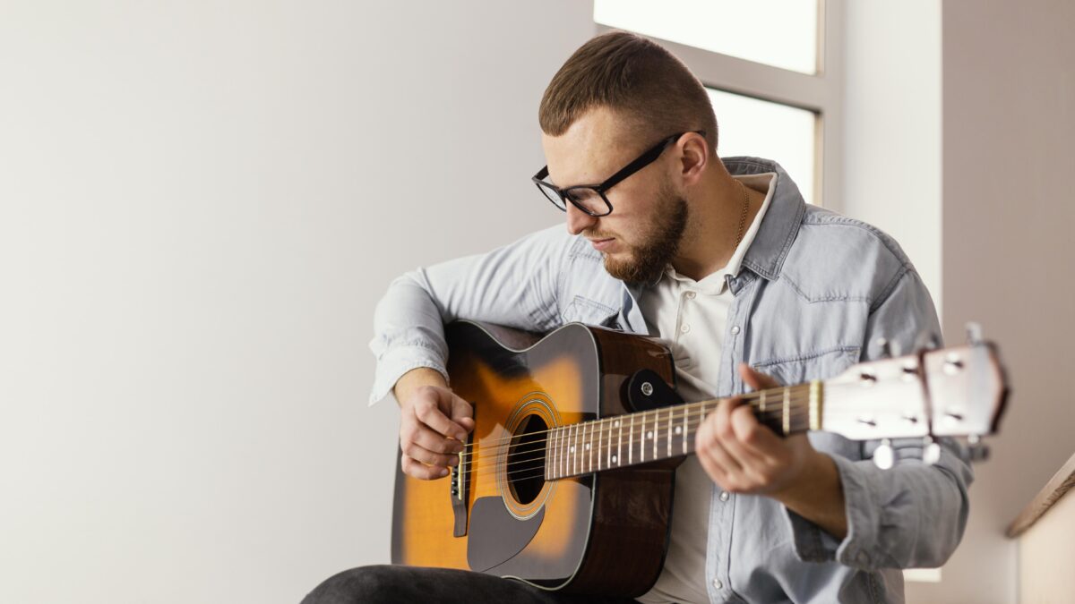 homem tocando violão e demonstrando sua habilidade musical