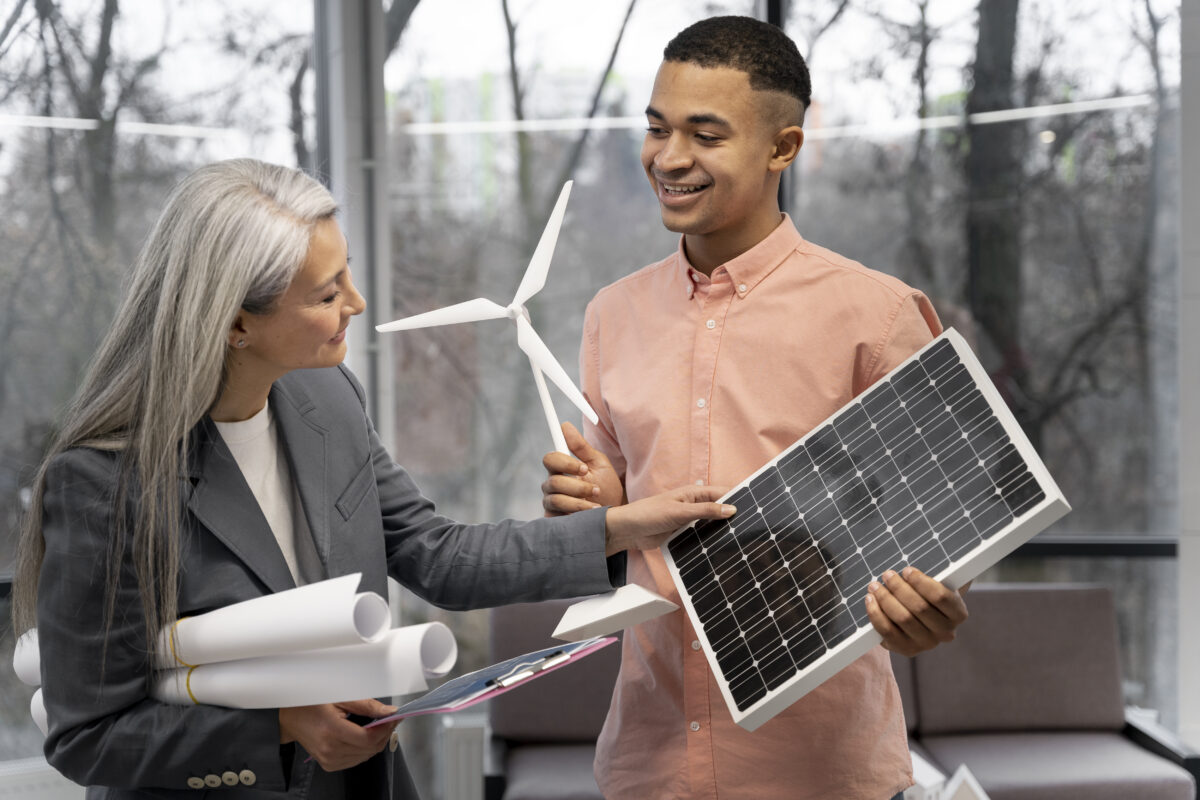 mulher e homem analisando modelos de energia renovável, como eólica e solar 