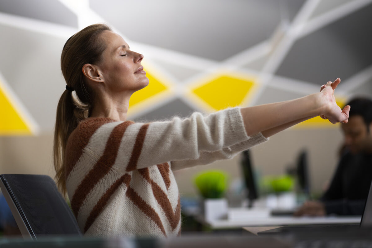 colaboradora tirando um tempo para se alongar durante o período de trabalho