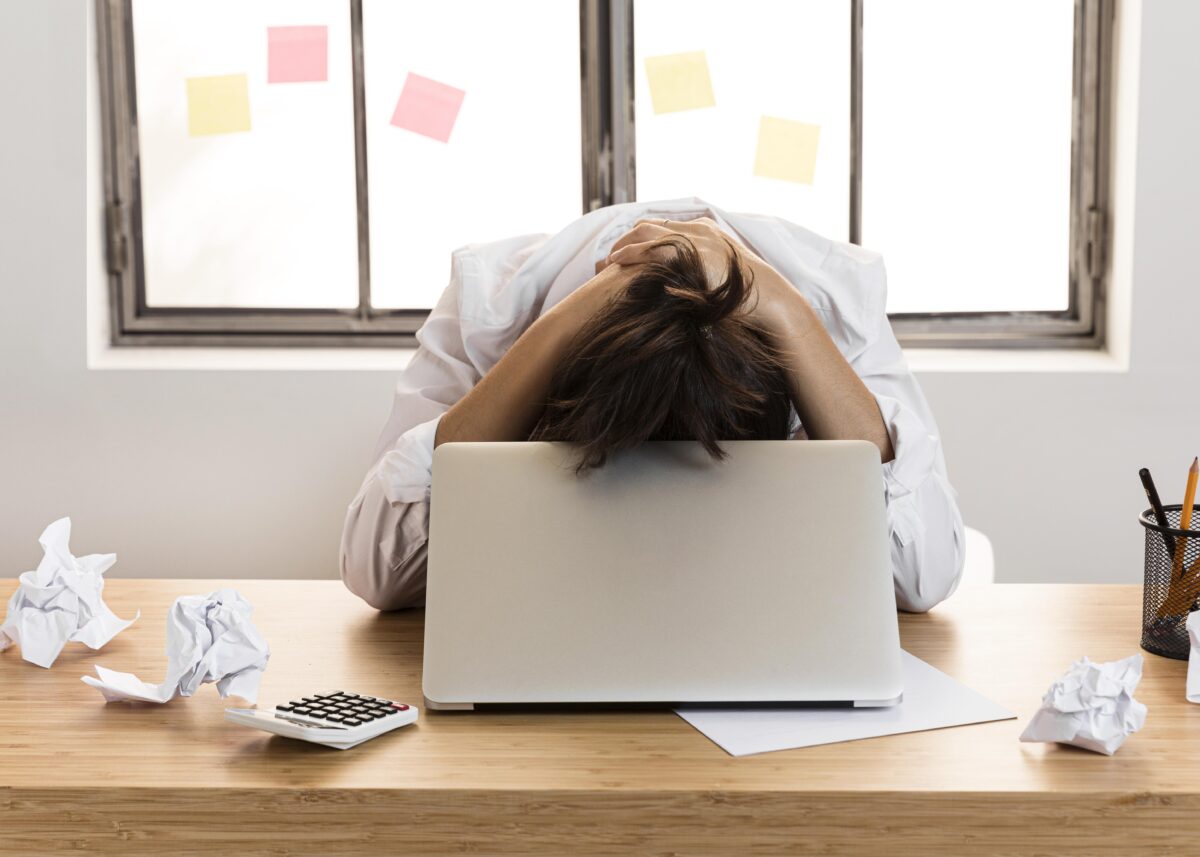 Colaboradora triste e estressada em sua mesa de trabalho