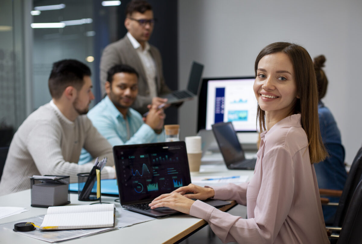 mulher em ambiente corporativo trabalhando no computador, analisando gráficos e dados