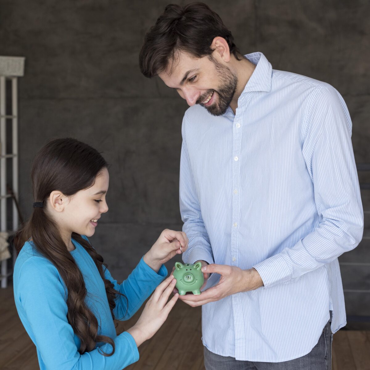 homem feliz com sua filha colocando dinheiro no cofrinho com o 13º salário