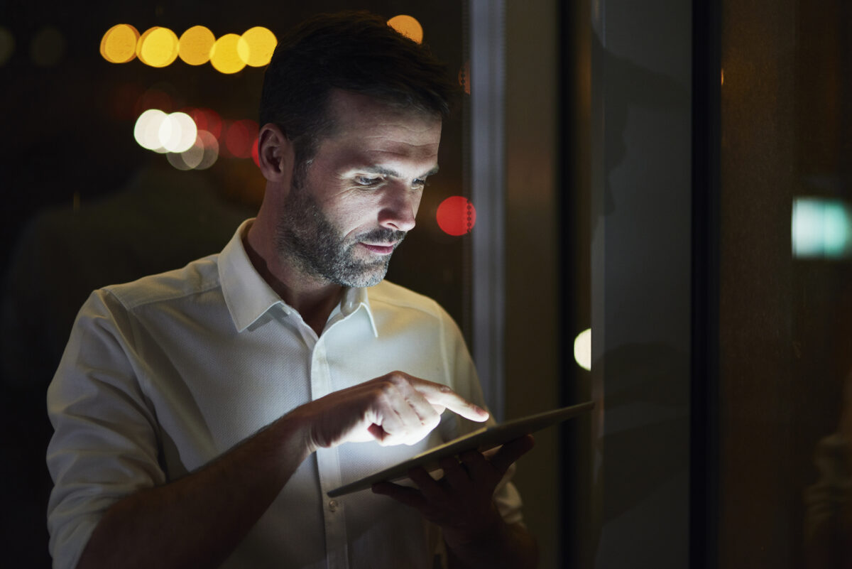 Funcionário em trabalho remoto registrando hora trabalhada em tablet no controle de ponto digital